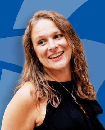 Smiling woman with wavy hair against a blue background.