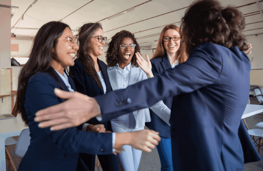 Women greeting each other warmly in a professional setting.