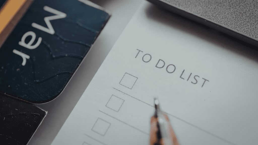 Blank to-do list with pen and laptop