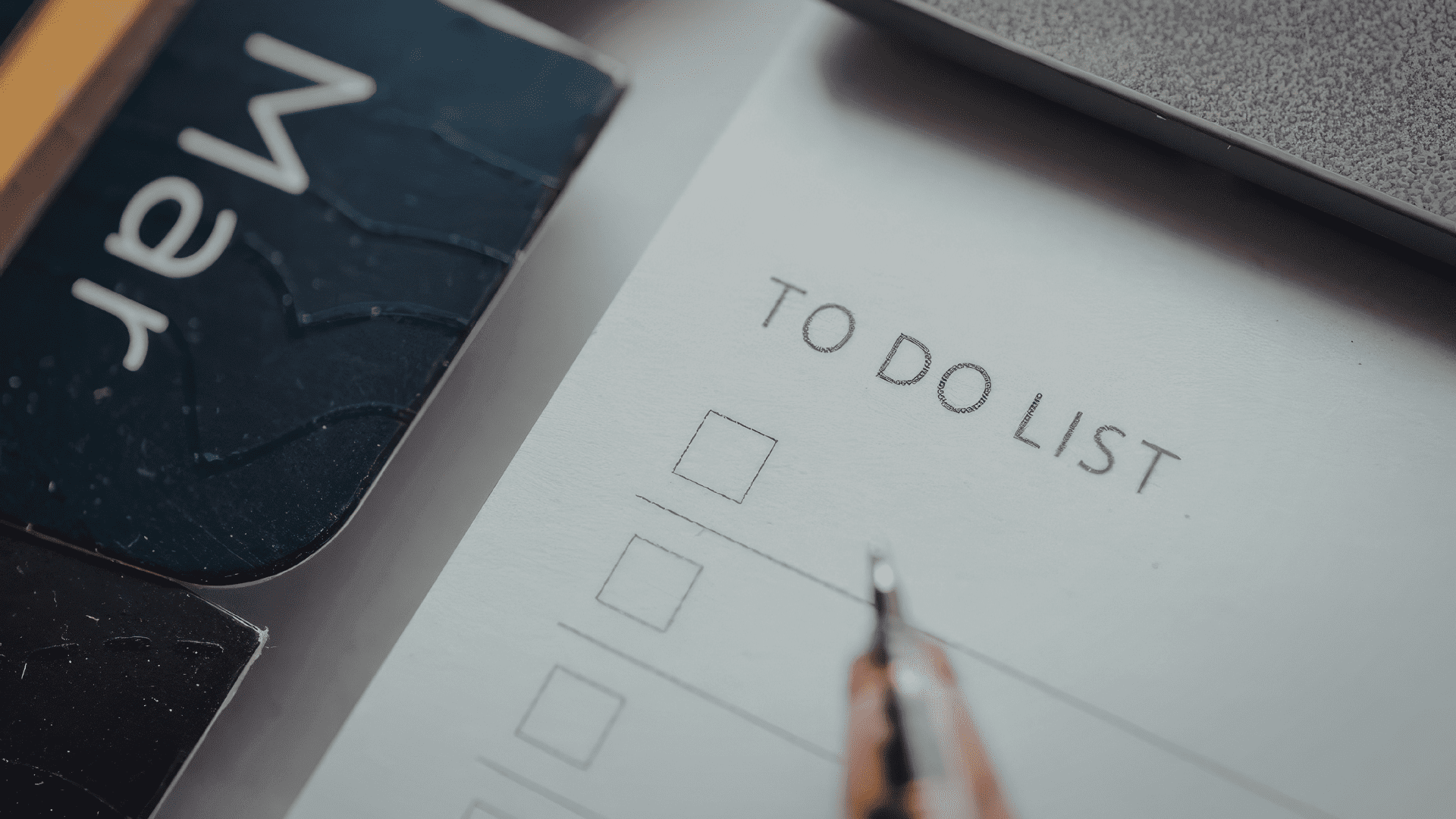 Blank to-do list with pen and laptop